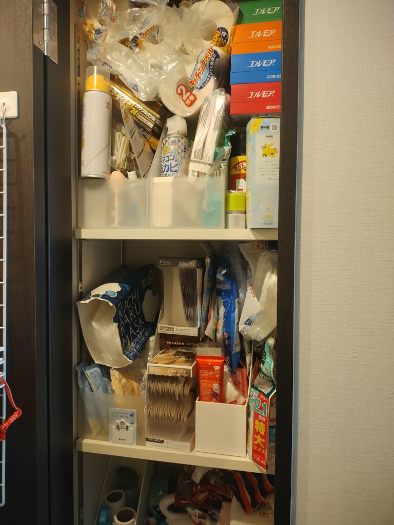 マンションの廊下収納。奥行きがあり、幅が狭く使いづらく、物がおしこまれた状況。